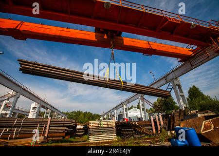 Podolsk, Moscow province - August 02, 2021: Pipes warehouse. Overhead crane move pipes. No people, wide-angle view Stock Photo