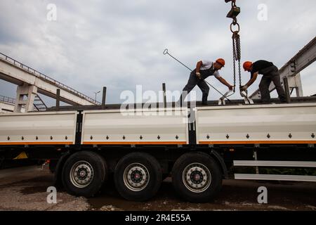 Podolsk, Moscow province - August 02, 2021: Pipes warehouse. Workers loads pipes in truck with overhead crane Stock Photo