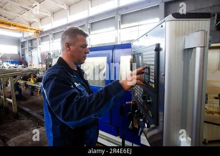 Podolsk, Moscow province - August 02, 2021: Production of oil drill pipes. Operator programming CNC machine Stock Photo