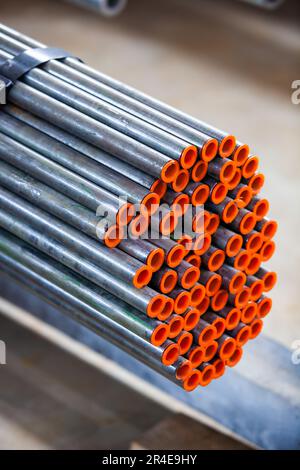 Stainless steel pipes with red caps on warehouse. Stock Photo