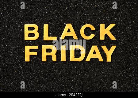 Black Friday - Text by golden letters in the black sand Stock Photo