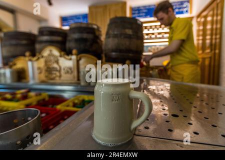 A stone mug of beer stands on the counter at the Augustiner Bräu, founded in 1621, in Salzburg, Austria. The beer, brewed according to a secret recipe, comes from wooden barrels and is served in stone mugs. Stock Photo