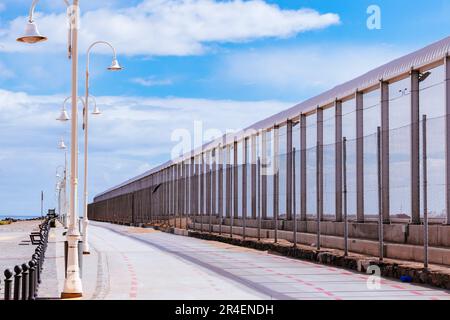 Fence that separates the city of Melilla from the Moroccan port of Nador. The Melilla border fence forms part of the Morocco–Spain border in the city Stock Photo