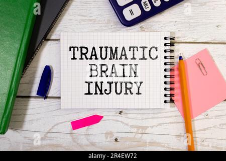 TBI text written in a notebook lying on a desk and a stethoscope. Medical concept Stock Photo