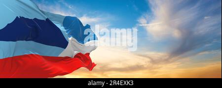 official flag of Sabah Malaysia at cloudy sky background on sunset, panoramic view. Malaysian travel and patriot concept. copy space for wide banner. Stock Photo