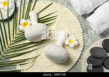 Spa bags, stones and orchid flowers on light gray marble table, flat lay Stock Photo