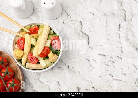 Tasty baby corn with vegetables and champignons on grey textured table, flat lay. Space for text Stock Photo