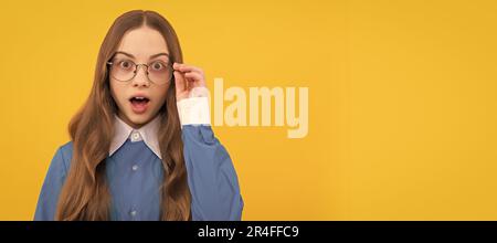 Surprised teenage girl fix eyeglasses yellow background, surprise. Child face, horizontal poster, teenager girl isolated portrait, banner with copy Stock Photo