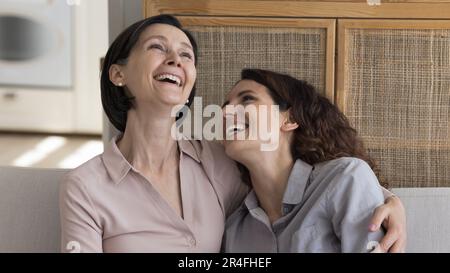 Cheerful mature mom and happy daughter excited with funny conversation Stock Photo