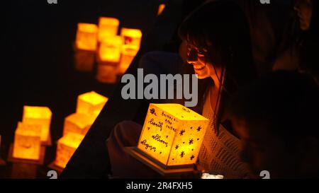 Houston, USA. 27th May, 2023. A woman waits to set afloat her lantern during the Water Lantern Festival held in Houston, Texas, the United States, May 27, 2023. Credit: Xu Jianmei/Xinhua/Alamy Live News Stock Photo