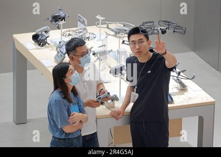 YANTAI, CHINA - MAY 27, 2023 - An employee of a DJI experience store displays a DJI drone in Yantai, East China's Shandong province, May 27, 2023. Stock Photo