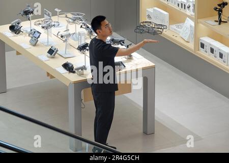 YANTAI, CHINA - MAY 27, 2023 - An employee of a DJI experience store displays a DJI drone in Yantai, East China's Shandong province, May 27, 2023. Stock Photo