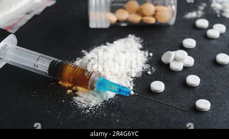 Syringe, pills and powder on black background, closeup. Hard drugs Stock Photo