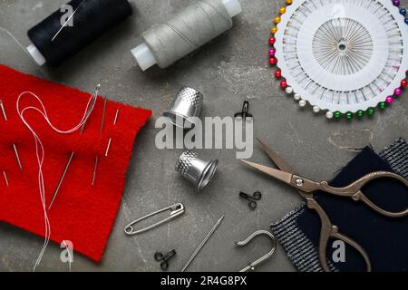 Flat lay composition with thimbles and different sewing tools on grey table Stock Photo