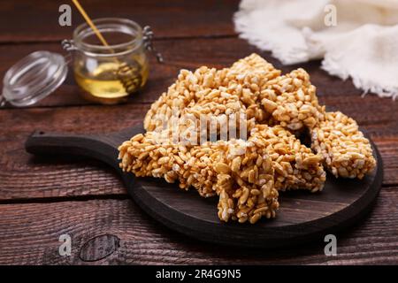 Board with puffed rice bars (kozinaki) on wooden table Stock Photo