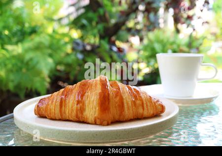 Delectable French Croissant with Coffee on a Garden Table Stock Photo