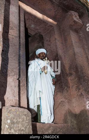 Priest with cross, rock church, crucifix, rock church, church carved in rock, Bet Giyorgis, St. George, Lalibela, Amhara region, Northern Ethiopia Stock Photo