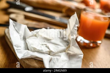Delicious brie cheese with white mold on a kitchen table Stock Photo