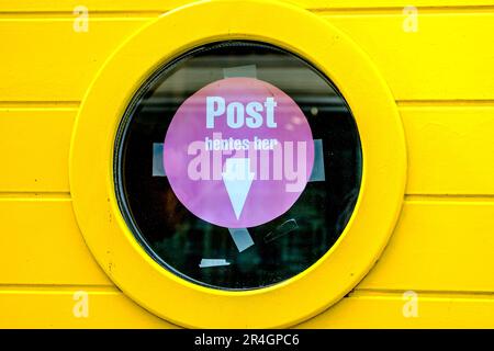 Stavanger, Rogaland, Norway, May 19 2023, Bright Yellow Painted Wall With Circular Round Window With Pink Notice And No People Stock Photo