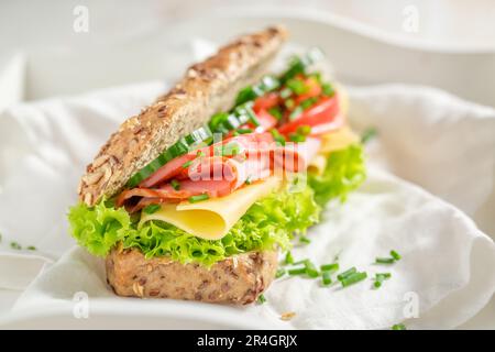 Delicious and homemade sandwich with ham, cheese and chive. Wholesome sandwich full of protein and fiber. Stock Photo