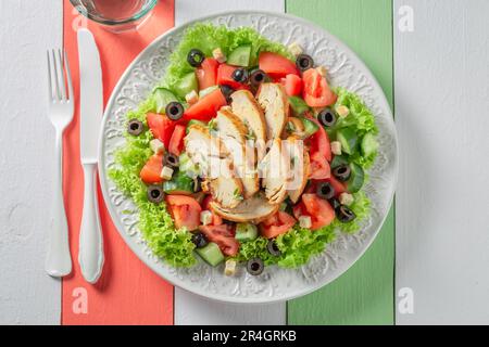Delicious and fresh Caesar salad with chicken, lettuce and tomatoes. Traditional Caesar Salad. Stock Photo