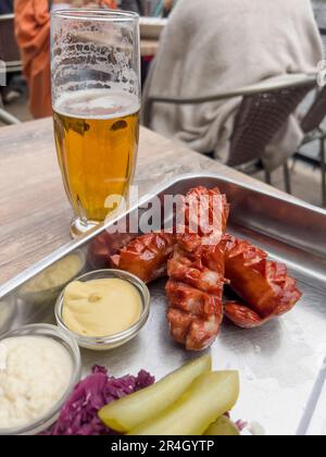 food, delicious grilled sausages with pickles and glass of cold beer on table with selective focus. October fest food and drink concept. bbq sausage a Stock Photo