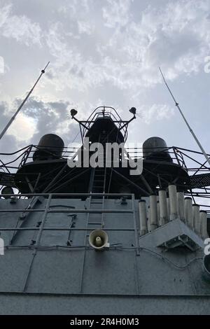 Outside details of retired vintage military naval sea vessel navy warship number, heavy machine gun, nautical flag, antenna, bridge of destroyer Stock Photo