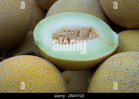Whole and half cut melons in carton box for sale in super market Stock Photo