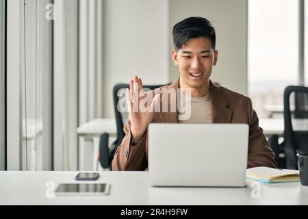 Young happy Asian business man manager having remote video conference meeting. Stock Photo