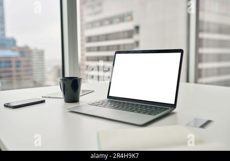 Laptop computer with white mock up empty blank screen on desk in office. Stock Photo