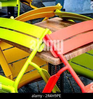 Stavanger, Rogaland, Norway, May 19 2023, Abstract Stack Or Group Of Bright Coloured Chairs In A Cafe Outside Seating Area With No People Stock Photo