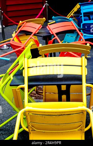 Stavanger, Rogaland, Norway, May 19 2023, Abstract Stack Or Group Of Bright Coloured Chairs In A Cafe Outside Seating Area With No People Stock Photo