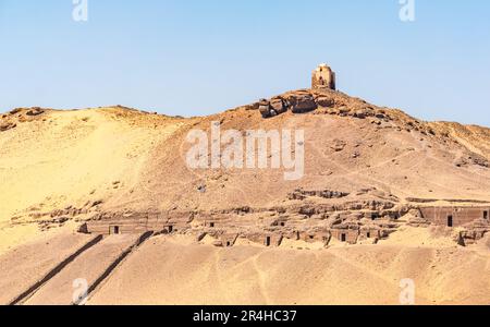 Qubbet el Hawa domed hilltop tomb with ancient tombs of nobles in desert cliff, West bank, River Nile, Aswan, Egypt, Africa Stock Photo
