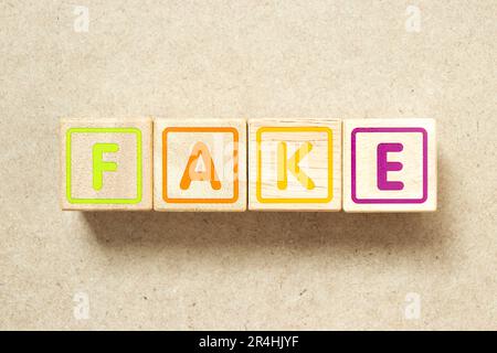 Wooden alphabet letter block in word fake on wood background Stock Photo