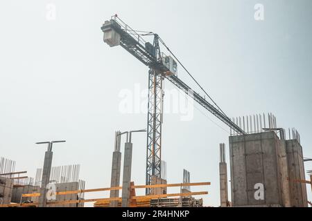 Construction site, crane rising above the building under construction, Construction going on Stock Photo
