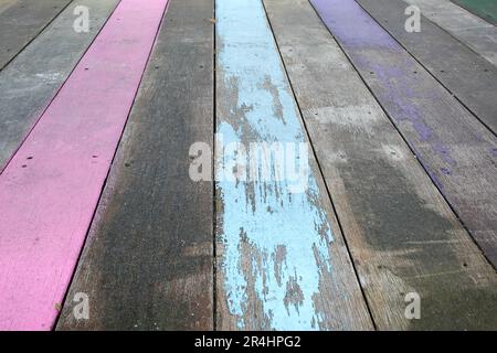 Faded purple, pink and aqua paint on weathered wooden deck Stock Photo