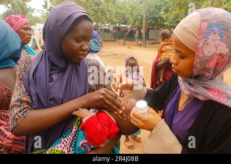 People are seen receiving free medical care at a makeshift shelter at the Durumi IDP Camp in Abuja. The Durumi IDP Camp houses over 2,000 internally displaced persons. People displaced are sheltered in camps due to insurgency in the northeastern provinces of Nigeria which continues to increase every day. Nigeria. Stock Photo