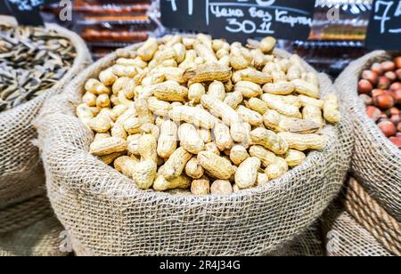 Unpeeled peanuts in a canvas bag are sold in a store Stock Photo
