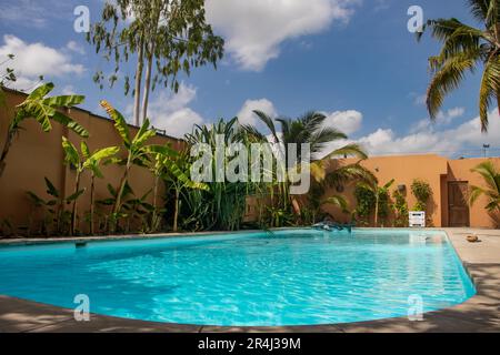 Swimming pool in tropical paradise with palm trees around and crystal clear blue water, perfect touristic destination for relax and holidays Stock Photo