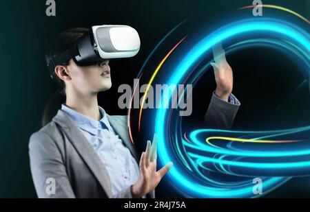 Business lady in VR headset touching virtual holographic smears, exploring, planning strategy in cyberspace Stock Photo