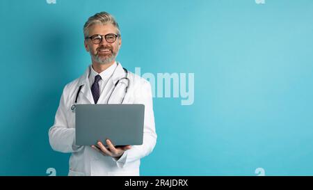 Friendly middle aged doctor using laptop, copy space Stock Photo