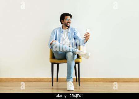 App and social networks, communication remotely. Positive millennial middle eastern man blogger Stock Photo
