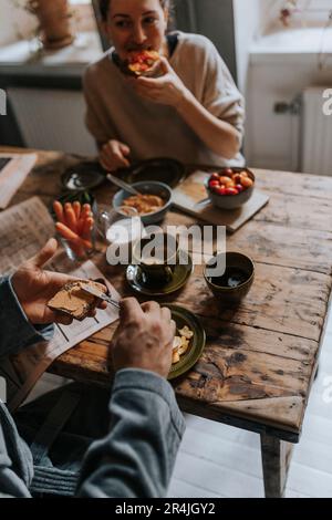 High angle view of man spreading peanut butter on bread while having breakfast at home Stock Photo