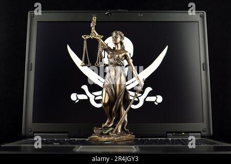Symbol of law and justice with Pirate Flag on laptop. Studio shot. Stock Photo