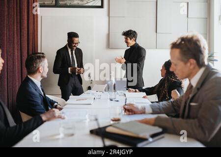 Happy male entrepreneurs discussing during business meeting at office Stock Photo