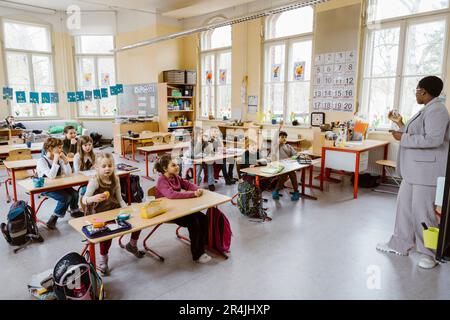 Teacher with boys and girls in classroom at school Stock Photo