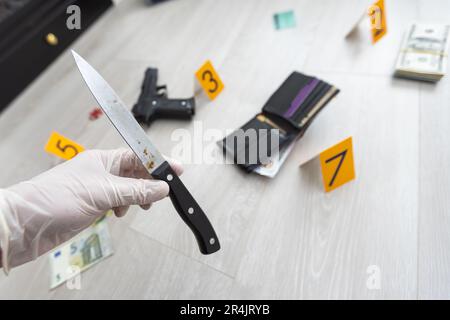 Crime scene investigation, picking up the tossed syringe and putting it to the plastic bag Stock Photo