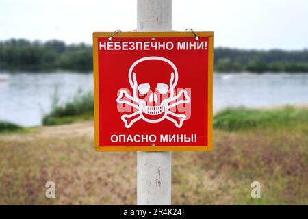 Russia war against Ukraine, Ukrainian war. Red sign skull and bones, danger sign from mines, minefields. inscription in Ukrainian and Russian - Danger Stock Photo