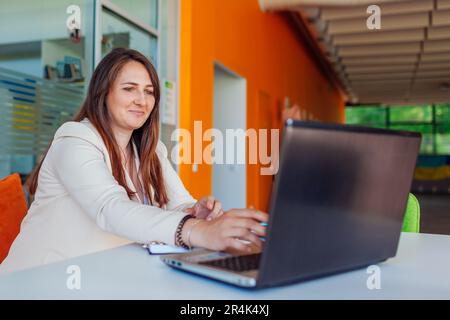 Young businesswoman teacher tutor talking to cowokers students in online chat through video conference calling on laptop. Internet meeting and teachin Stock Photo