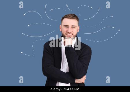 Choice in profession or other areas of life, concept. Making decision, young man surrounded by drawn arrows on color background Stock Photo